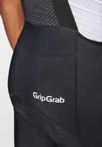 Pantaloncini da ciclismo neri con un design elegante, tessuto elasticizzato e cuciture a contrasto. Presenta il logo bianco "GripGrab" sul lato.