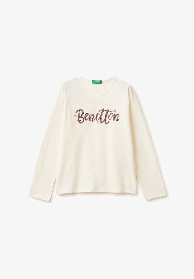 Krémová košile s dlouhým rukávem vyrobená z bavlny, s nápisem "Benetton" v třpytivě růžovém a hnědém písmu, s malými hvězdicemi nad a pod nápisem.