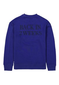 Sudadera azul con mangas largas, puños y dobladillo acanalados. El texto negro en la parte de atrás dice "VOLVER EN 2 SEMANAS", con una textura de tela suave.