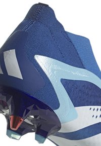 Fotbollssko med en överdel av marinblått och vitt textilmaterial, elegant design, rund tå och färgglada formade dobbar på sulan.