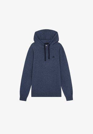 Bluza z kapturem z ciemnoniebieskiego materiału, beżowe spodnie, brązowe buty i czarna torba na ramię. Prosty design z przednią kieszenią i sznurkiem do ściągania.