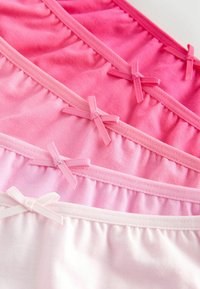 Fyra par av sträckliga bomullstrosor i olika nyanser av rosa, med rynkade midjeband och små rosetter som dekorativa detaljer.