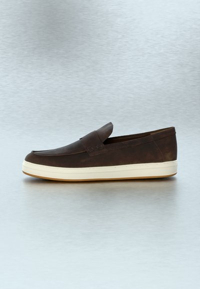 Mocassin à enfiler en cuir marron avec semelle en caoutchouc blanche sur une surface grise lisse, vue de côté montrant un design simple et épuré.