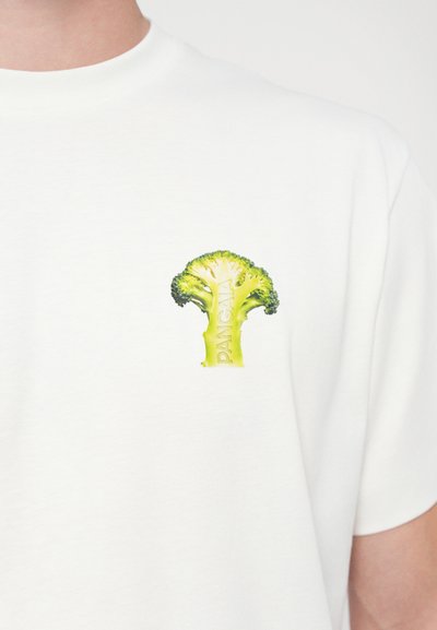 T-shirt en coton blanc arborant un graphique de brocoli vert avec un design texturé et le mot "PANGAEA" partiellement visible sur la tige.