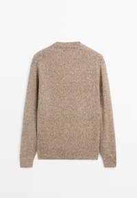 Maglione a maglia marrone, con una trama leggermente screziata. Design leggermente aderente, maniche lunghe e scollo a girocollo con polsini e orlo a costine.