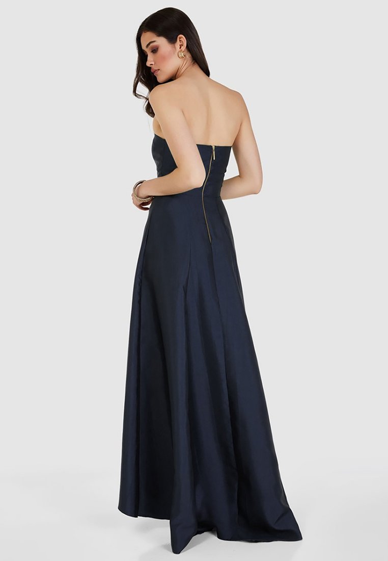 Abito da sera blu navy senza spalline, in morbido tessuto di satin, con corsetto aderente, gonna fluida, cerniera laterale e leggere pieghe per un movimento aggiuntivo.