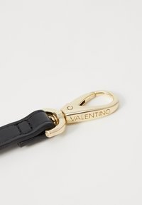 Schwarzer Lederband mit einem goldenen Metallverschluss. Der Verschluss trägt die gravierte Aufschrift "VALENTINO." Glatte Oberfläche mit glänzendem Finish.
