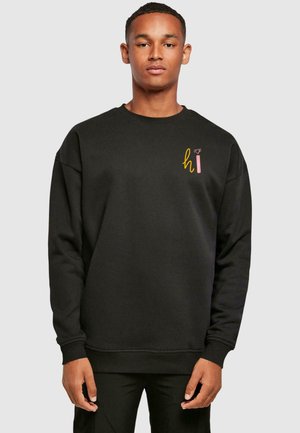 Sort sweatshirt, rund halsudskæring, lange ærmer, ribbede manchetter og kant. Har et flerfarvet "hi" grafik på brystet med en hjerte detalje.