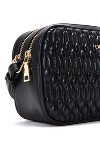 Borsa a tracolla nera in pelle trapuntata con hardware color oro, chiusura zip e forma arrotondata. Presenta una tracolla intrecciata e dettagli in finitura liscia.