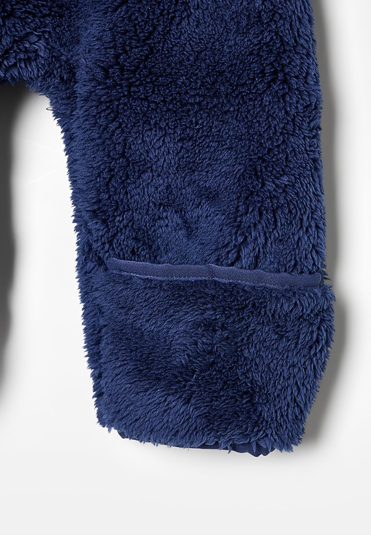 Marinblå plyschfleece tyg med en mjuk, texturerad yta. Inkluderar en sydd mudd i änden för en säker passform.