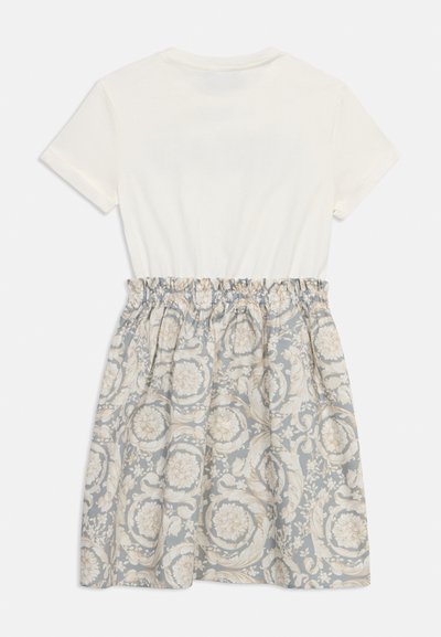 Λευκό τοπ με κοντά μανίκια στερεωμένο σε φούστα με ψηλή μέση, ελαστική ζώνη μέσης και μπλε-γκρι φλοράλ μπαρόκ μοτίβο.