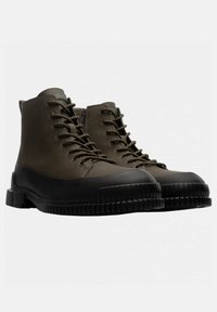 Stivali alla caviglia impermeabili color khaki con suole in gomma nera, motivi testurizzati, punte rinforzate e cerniere laterali per un facile accesso.