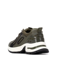 Zapatillas deportivas verde oliva con acentos negros, que cuentan con una parte superior texturizada, un collar acolchado y una suela gruesa blanca y negra.