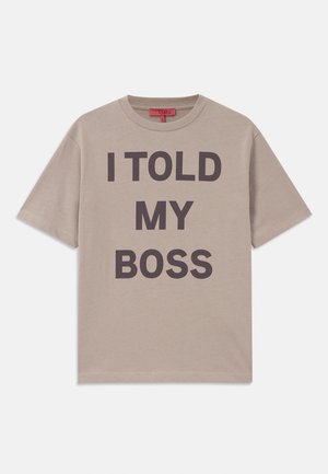 T-shirt en coton beige, à manches courtes, col rond, avec un texte audacieux en noir : "J'AI DIT À MON PATRON" imprimé en évidence sur le devant.