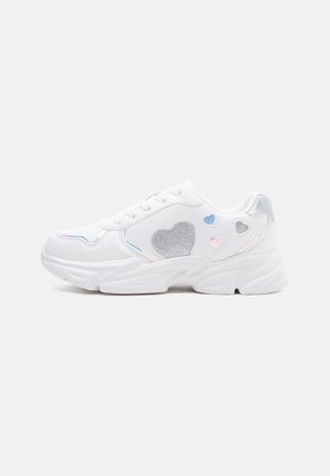 Bílá masivní teniska s třpytivými stříbrnými a duhovými srdíčky na boku, bílé tkaničky a silná podrážka.