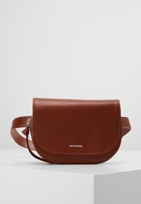 Bolso cruzado de cuero marrón con tapa redondeada, que presenta un logo plateado. Textura suave y correa ajustable para mayor comodidad al llevarlo.