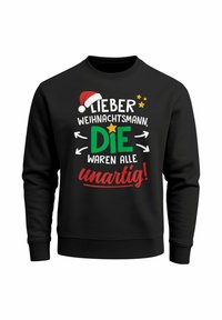 Black sweatshirt featuring colorful text with a Christmas theme, including a Santa hat, stars, and arrows. Text reads: "Lieber Weihnachtsmann, DIE waren alle unartig!"