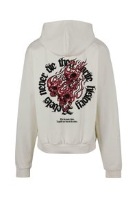 Felpa bianca con cappuccio caratterizzata da una grafica di tre teschi rossi circondati da fiamme. Testo in nero: "Non morire mai nella storia del fuoco."