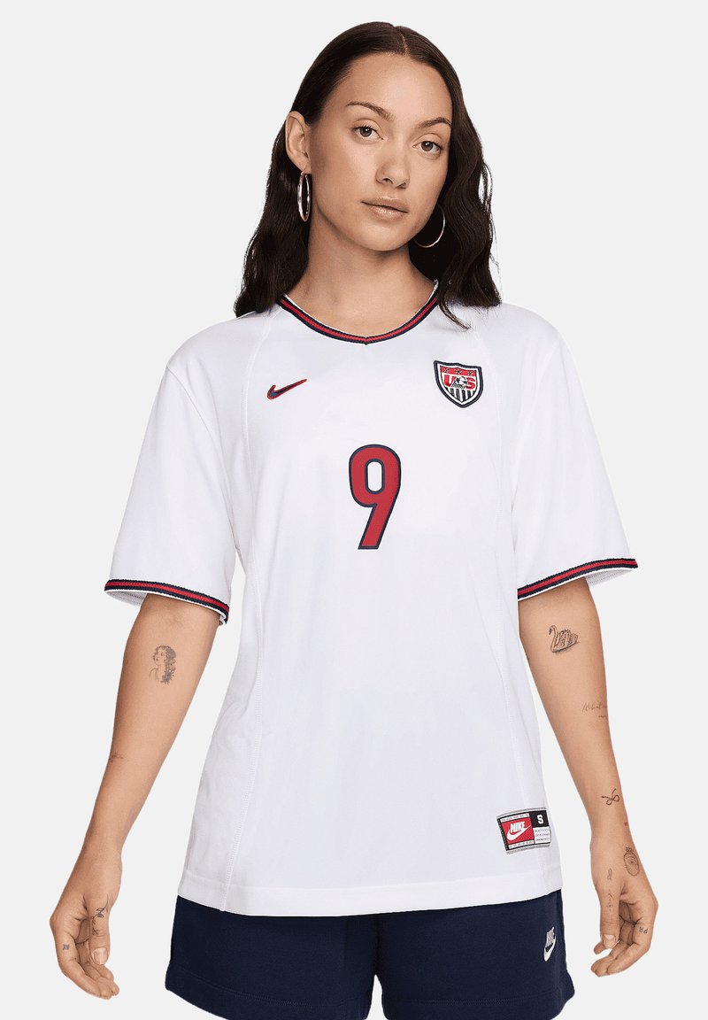 Maglietta da calcio Nike bianca con maniche corte, accenti rossi e blu, collo rotondo e numero 9 stampato sulla parte anteriore.