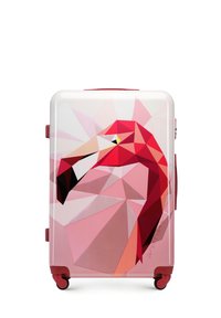 Valise rigide avec un design de flamant rose géométrique, accents rouges et roulettes noires. Surface texturée au fini brillant.