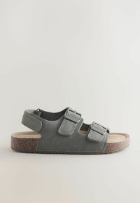 Sandale ouverte en daim gris avec deux brides ajustables à boucle et une bride arrière en velcro sur une semelle plate en liège.