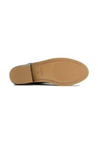 Vegan shoe sole with a textured, light brown rubber surface, featuring ridged patterns for traction and a flat profile.