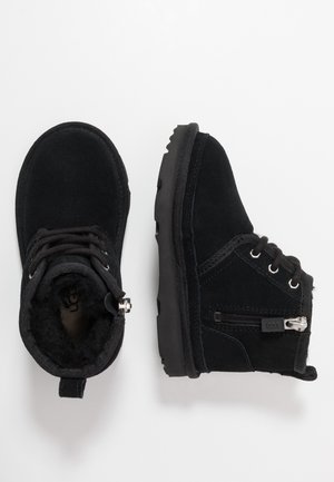 Bottes noires en suède à talons avec une doublure intérieure douce, des semelles en caoutchouc, des lacets et un zip latéral pour un enfilage facile.