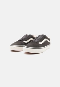 Adidași din suede negru cu accente de crem, având vârful rotund, talpă albă plată și șireturi gri. Fata de blană vizibilă la guler.