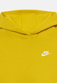 Hanorac galben cu buzunar frontal și glugă cu șnur. Prezintă un logo alb Nike pe piept. Fabricat dintr-un material moale și neted.