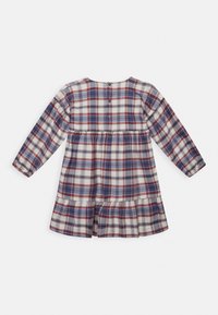 Červené, námořnické a bílé kostkované šaty s dlouhými rukávy, řaseným pasem a vrstvenou sukní. Zadní zapínání na knoflíky se třemi knoflíky.