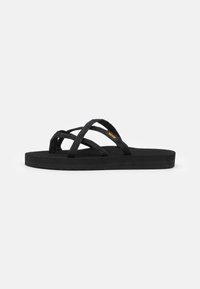 Chanclas negras con tiras de tela cruzadas, suelas negras texturizadas y diseño ligero. Minimalistas, sin adornos.