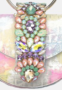 Adorno de joyas coloridas en un bolso de tonos pasteles, con formas variadas de piedras brillantes y cristales en tonos de verde, púrpura y durazno.