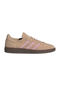 Beige suède sneaker met drie roze strepen, platte veters, bruine rubberen zool en gouden branding op de tong. Klassiek ontwerp, laag model.