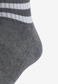 Grijze katoenen sok met witte strepen aan de bovenkant, met een gladde textuur en een versterkte teen en hiel voor duurzaamheid.