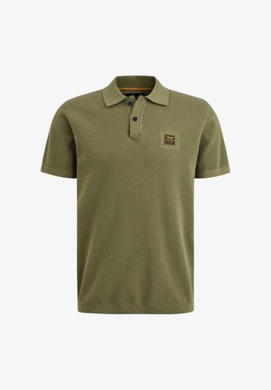 Polo shirt verde oliva in tessuto strutturato, con colletto a tre bottoni, maniche corte e una piccola etichetta con il marchio sul petto.
