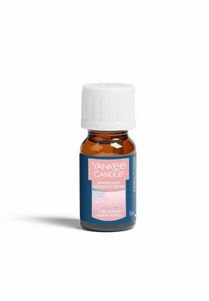 Klein amberkleurig flesje met witte dop, gelabeld Yankee Candle diffuser blend in Pink Sands geur, 10 ml inhoud, tegen een witte achtergrond.