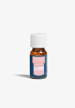 Klein amberkleurig flesje met witte dop, gelabeld Yankee Candle diffuser blend in Pink Sands geur, 10 ml inhoud, tegen een witte achtergrond.