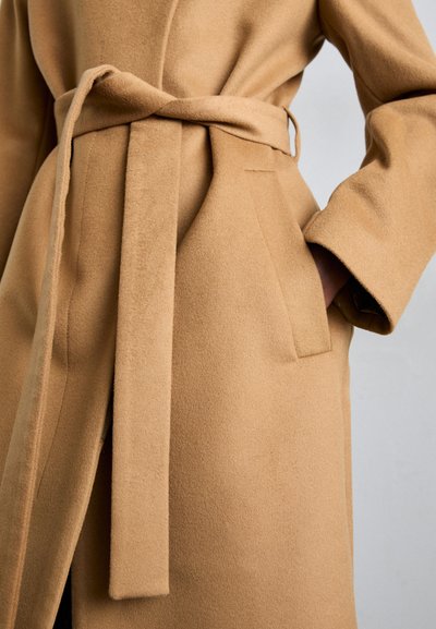 Camel-colored wool coat with a tie belt, long sleeves, and side pockets; features smooth texture and a tailored silhouette.