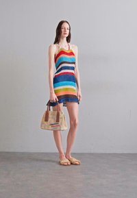 Rochie colorată cu dungi, cu textură striată, combinată cu o geantă de umăr cu model și sandale de culori deschise. Design minimalist, cu un top tip halter.