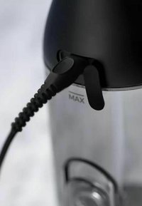 Zwarte kunststof handgreep en tuit van een metalen blender, met een "MAX" label. Getextureerde kabel wikkelt zich om de handgreep.