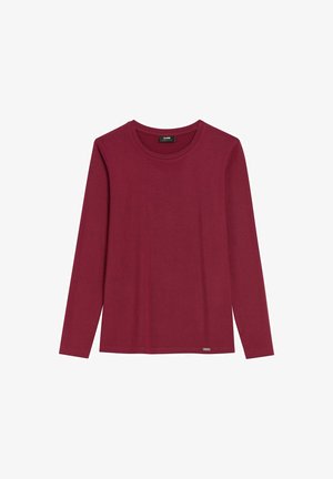 Czerwona koszulka z długim rękawem, wykonana z miękkiej bawełny. Posiada okrągły dekolt oraz małe logo w pobliżu dolnego brzegu. Gładka faktura na całej powierzchni.