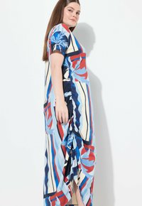 Maximekkoinen, jossa on rohkeat punaiset, siniset ja kermansävyiset raidat kukkakuviolla. Valmistettu kevyestä kankaasta, sisältää sivuhalkion ja lyhyet hihat.