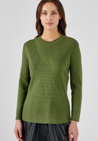 Pull en maille côtelée verte avec un motif diagonal texturé, manches longues et col rond, présentant une silhouette ajustée.