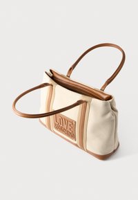Τσάντα tote από καμβά σε μπεζ χρώμα με καφέ συνθετικές δερμάτινες λεπτομέρειες. Διαθέτει ανάγλυφο, εμφανές λογότυπο "LOVE MOSCHINO" στο μπροστινό μέρος και διπλούς ιμάντες.