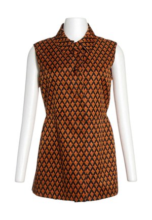 Top sin mangas de color marrón y negro con estampado geométrico, con cuello y botones delanteros, mostrado en un torso de maniquí blanco.