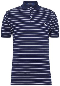 Mörkblå polo med vita horisontella ränder, korta ärmar, krage och tre knappar. Har en liten broderad logotyp på bröstet.