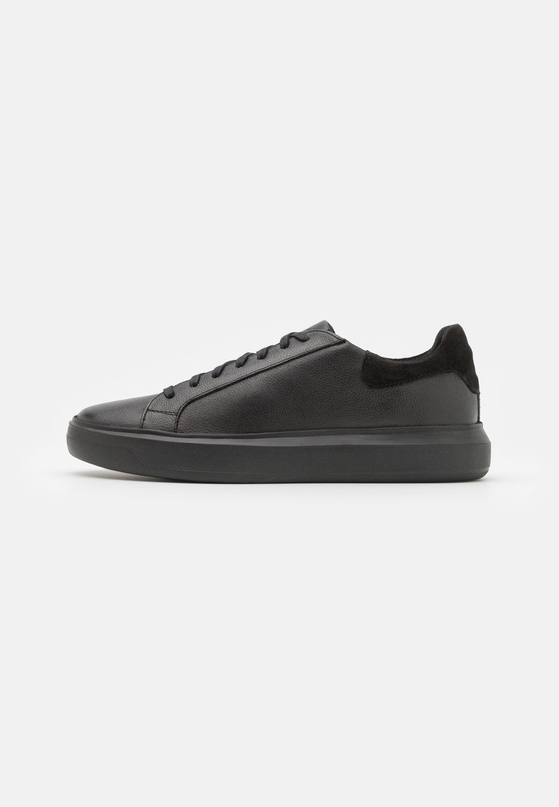 Sneakers in pelle nera con una texture liscia, punta rotonda e accenti in suede nero a contrasto sul tallone e sulla linguetta. Suola in gomma.
