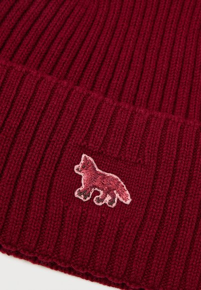 Κόκκινο ριμπά βελούδινο σκουφί κατασκευασμένο από μαλακό νήμα, με ροζ κεντημένο λογότυπο αλεπούς μπροστά, προσφέροντας μια υφασμένη και άνετη εμφάνιση.