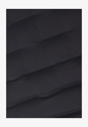 Tessuto blu navy con una superficie liscia, caratterizzato da linee diagonali che creano un motivo trapuntato. La superficie appare leggermente riflettente.