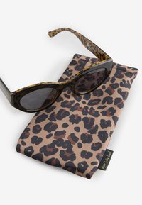 Okulary przeciwsłoneczne z ramką w czarno-brązowy wzór w cętki, zestawione z pasującym etui na okulary z podobnym wzorem w cętki.